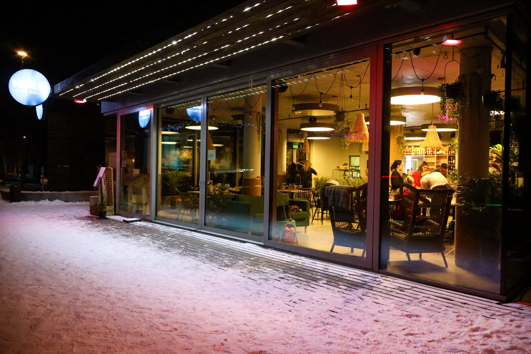 MOLO Bistro at night — pink glow and blue sign by Lake Ukiel